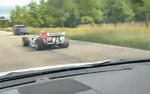 Formula 1 Car Weaving Through Traffic